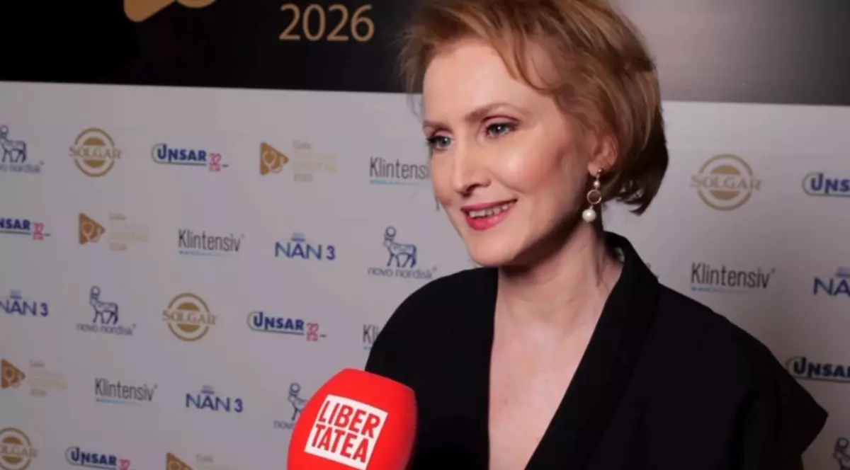 Laura Ene în timp ce dă un interviu. Aceasta poartă o ținută neagră și cercei.