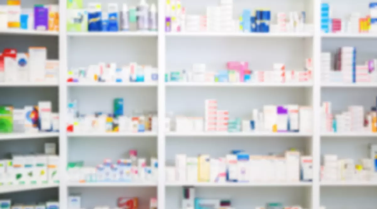 Medicamente aranjate în rafturi la farmacie