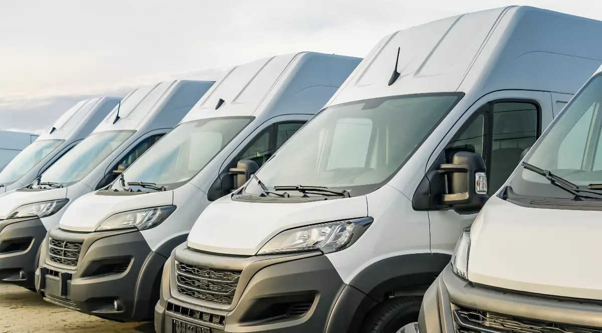 Mai multe microbuze albe parcate.