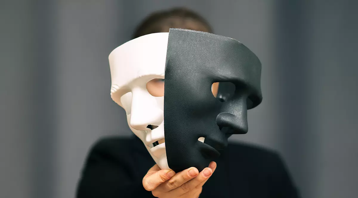 Un barbat cu doua masti un fata, una alba si una neagra