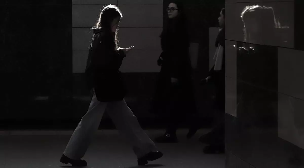 Mai multe tinere merg pe stradă, fotografia este întunecată și nu li se văd bine fețele, în București, 2026