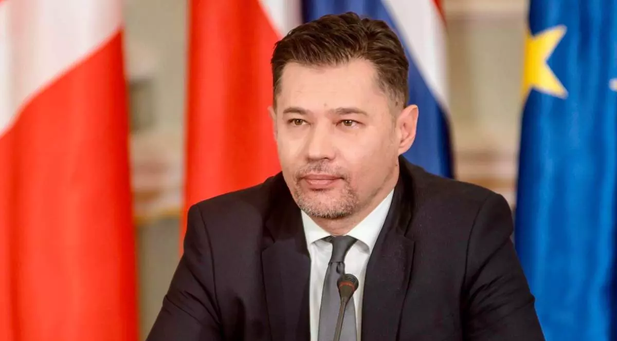 Olexander Scherba, Ambasadorul ucrainean în Africa de Sud, in costum negru, camasa alba, intr-un context oficial cu steaguri in spate