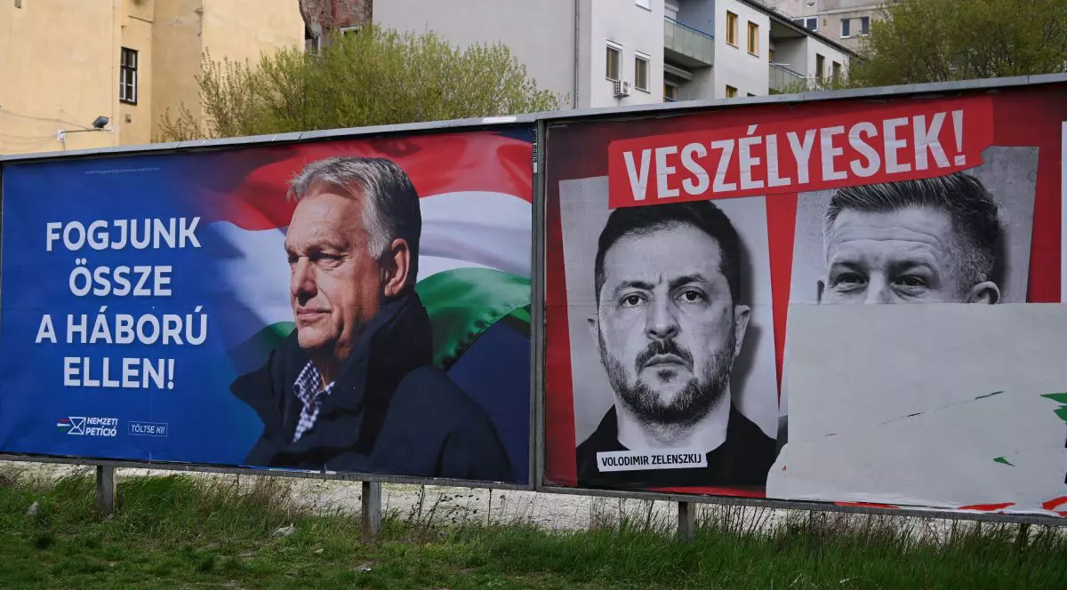 Un panou de campanie electorală pentru alegerile din Ungaria din 2026 în care apare Viktor Orban, iar în dreapta un banner cu Peter Magyar, liderul opoziției, și Volodimir Zelenski