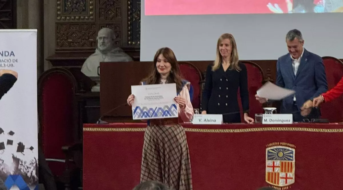 Elena Cioanu, românca studentă în Italia care a obținut cea mai mare notăr la examenul MIR, stând în amfiteatrul universității spaniole cu o diplomă în mână