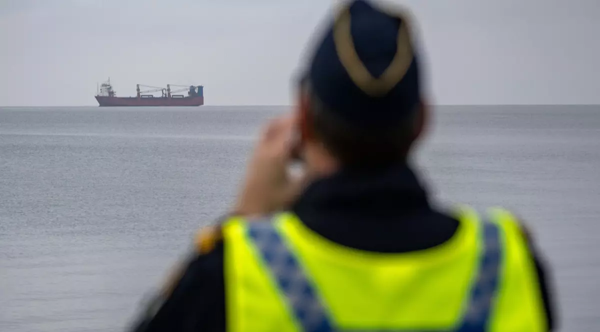 Un polițist al Gărzii de Coastă suedeze, în timp ce urmărește o navă de cereale