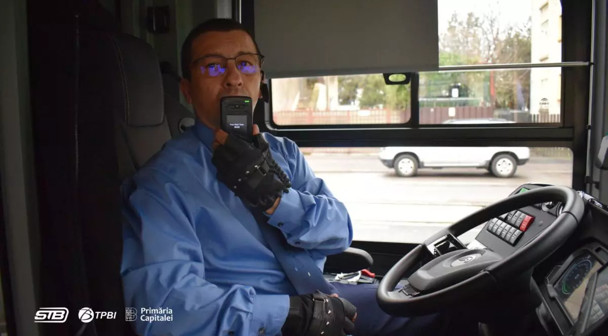 Unbărbat stă la volan și testează sistemul Alcolock care blochează motorul dacă șoferul a băut în noile troleibuze din București, aprilie 2026