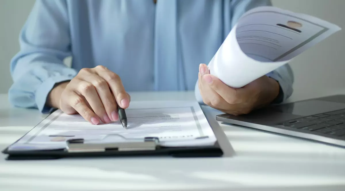 Persoana care semneaza un dosar cu acte