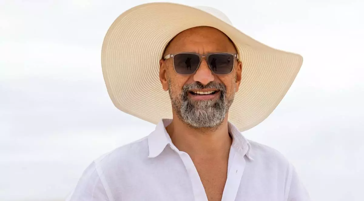Adrian Brînzoi, un bărbat din Brașov, cu palarie de paie pe cam si camasa alba, a transformat o vilă abandonată într-un resort de 3,5 milioane de dolari Kenya