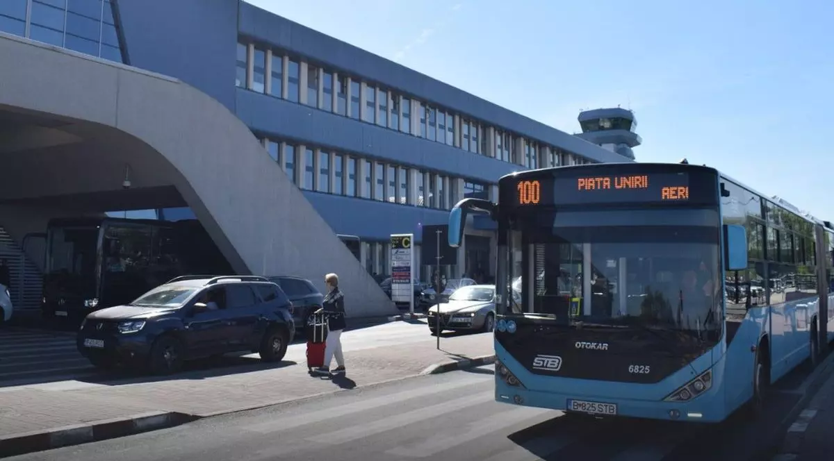Un autobuz al liniei 100 este în stația „Aeroport Henri Coandă Sosiri”, într-o zi însorită, 2026