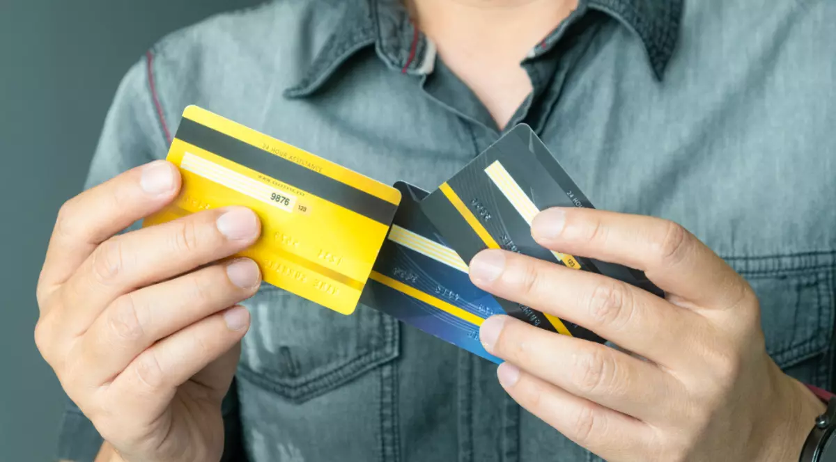 Un bărbat care ține în mână mai multe carduri