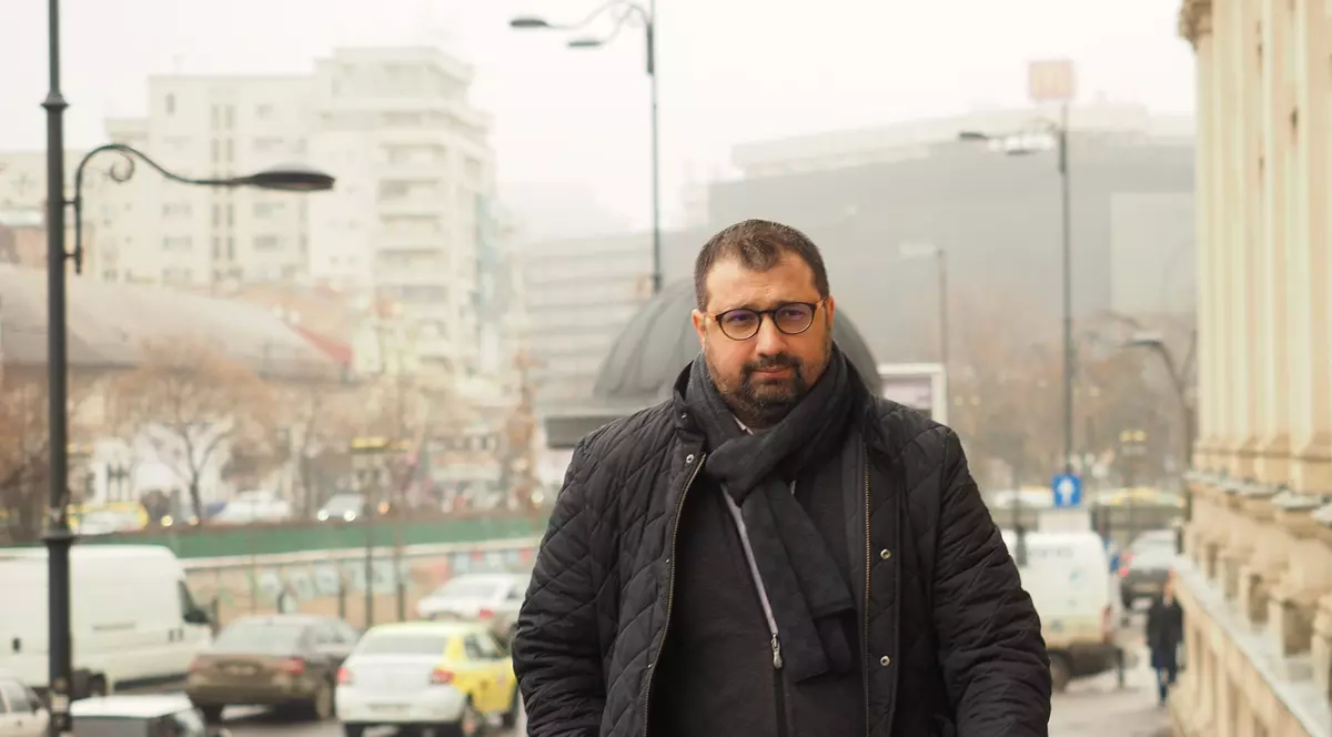 Un barbat imbracat in negru merge pe strada