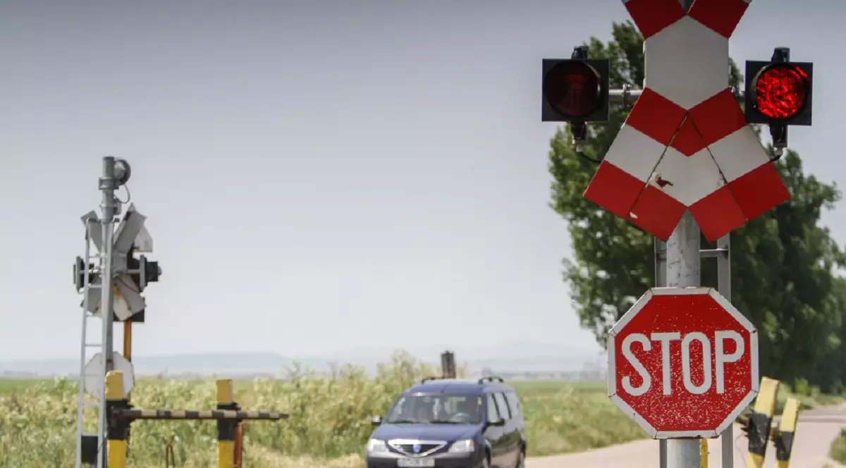 De ce semnul STOP este octogonal - O masina opreste la semnul stop, amplasat la o intersectie cu cale ferată
