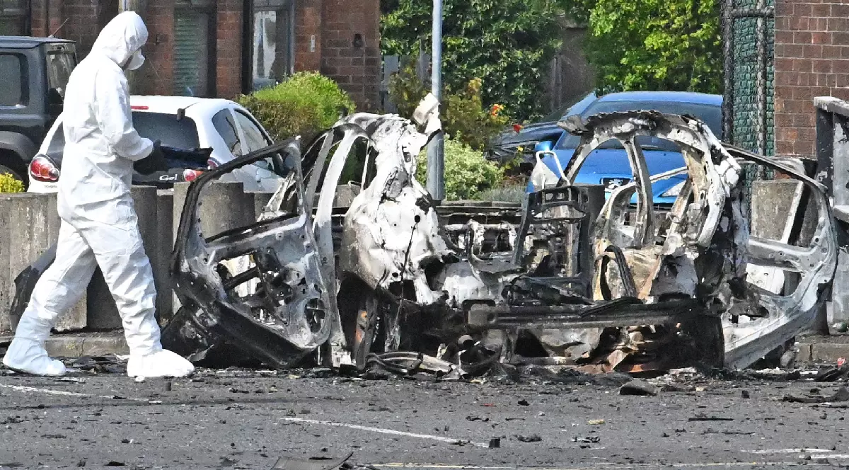 Ofițeri de la Poliția Criminalistă la locul exploziei unei mașini-capcană din fața secției de poliție Dunmurry, la periferia Belfastului.