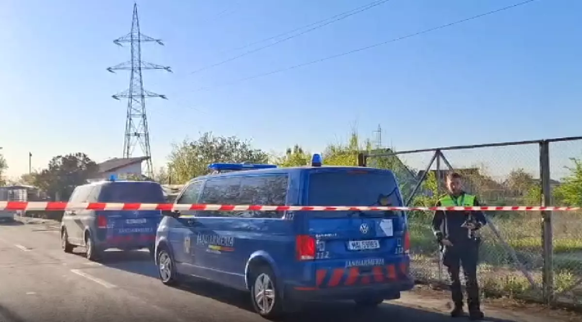Mai multe mașini de Jandarmerie albastre, un polițist care păzește zona din Galați în care au căzut fragmente de dronă.