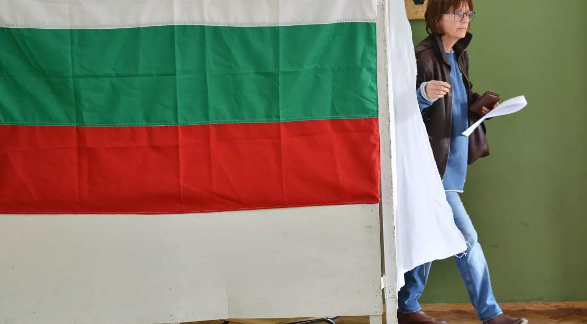 O femeie votează la o secție de votare pe din Sofia care este pus steagul Bulgariei, la alegerile parlamentare din Bulgaria, 26 martie 2017