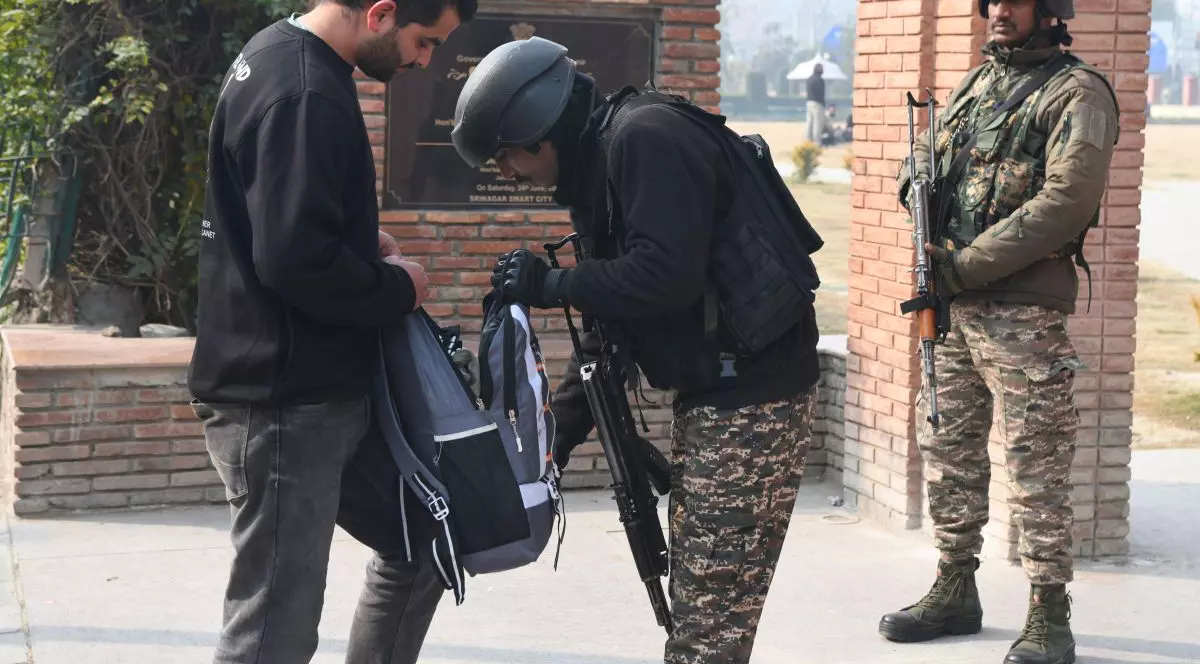 Un polițist indian verifică geanta unui pieton în Srinagar, 18 noiembrie 2025