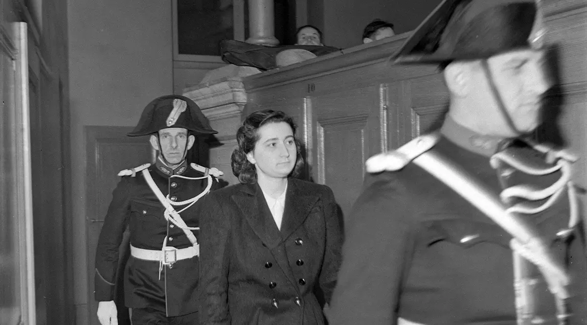 O femeie criminala in sala de judecata insotită de doi politisti