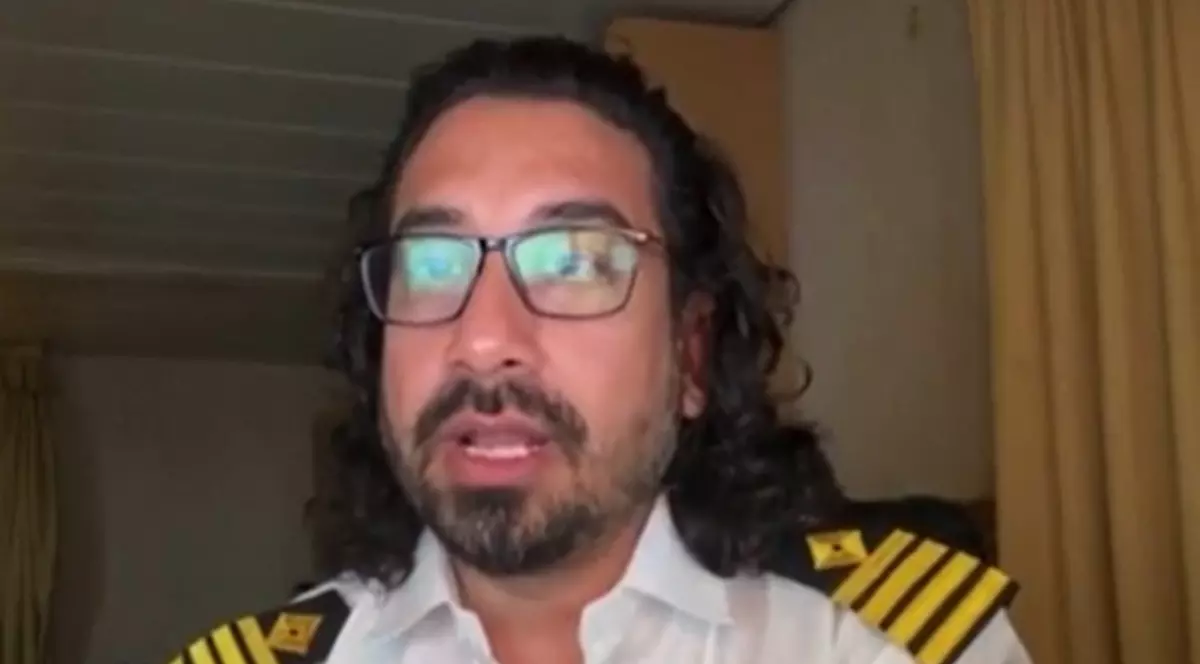 Căpitanul Raman Kapoor, îmbrăcat în uniformă, la bordul navei pe care o conduce și cu care este bocat în Strâmtoarea Ormuz