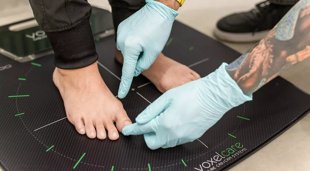 Un medic examineaza piciorul unui pacient