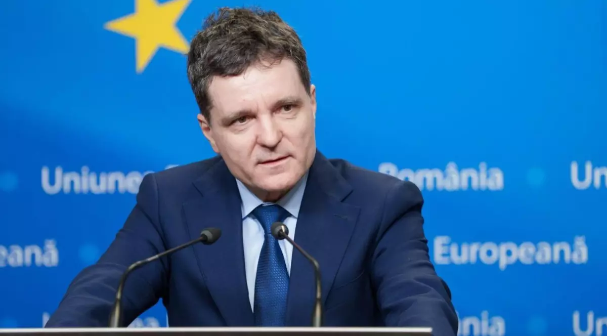 Nicușor Dan într-un costum albastru închis în timp ce vorbește la microfon.