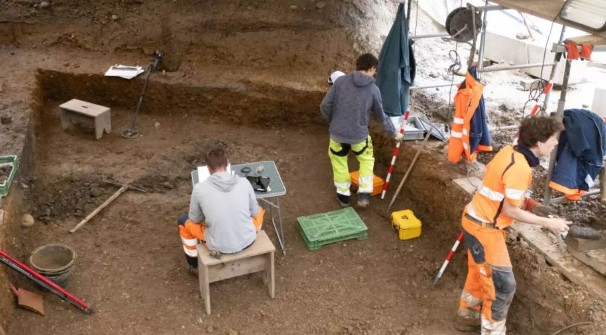 Arheologi lucrează într-un sit de excavare din Elveția, unde a fost descoperită o pâine romană carbonizată veche de 2.000 de ani, găsită în sol în timpul săpăturilor.