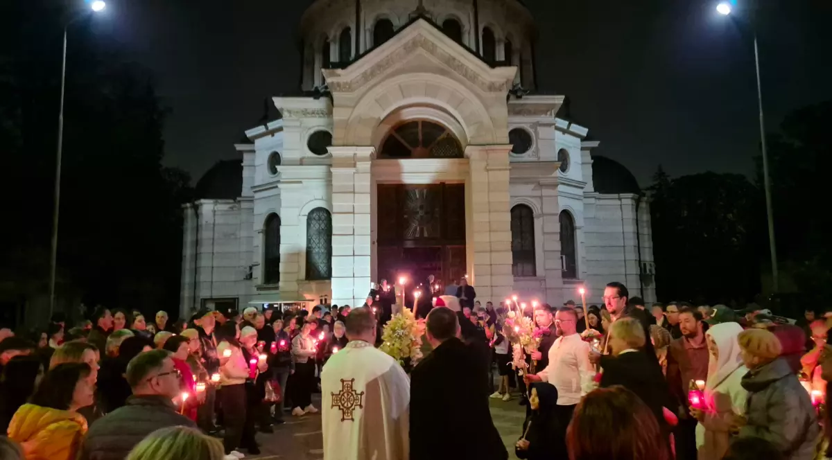 Credincioșii români la slujba de Paște din Noaptea de Înviere, stau în fața bisericii și iau lumină de la preot