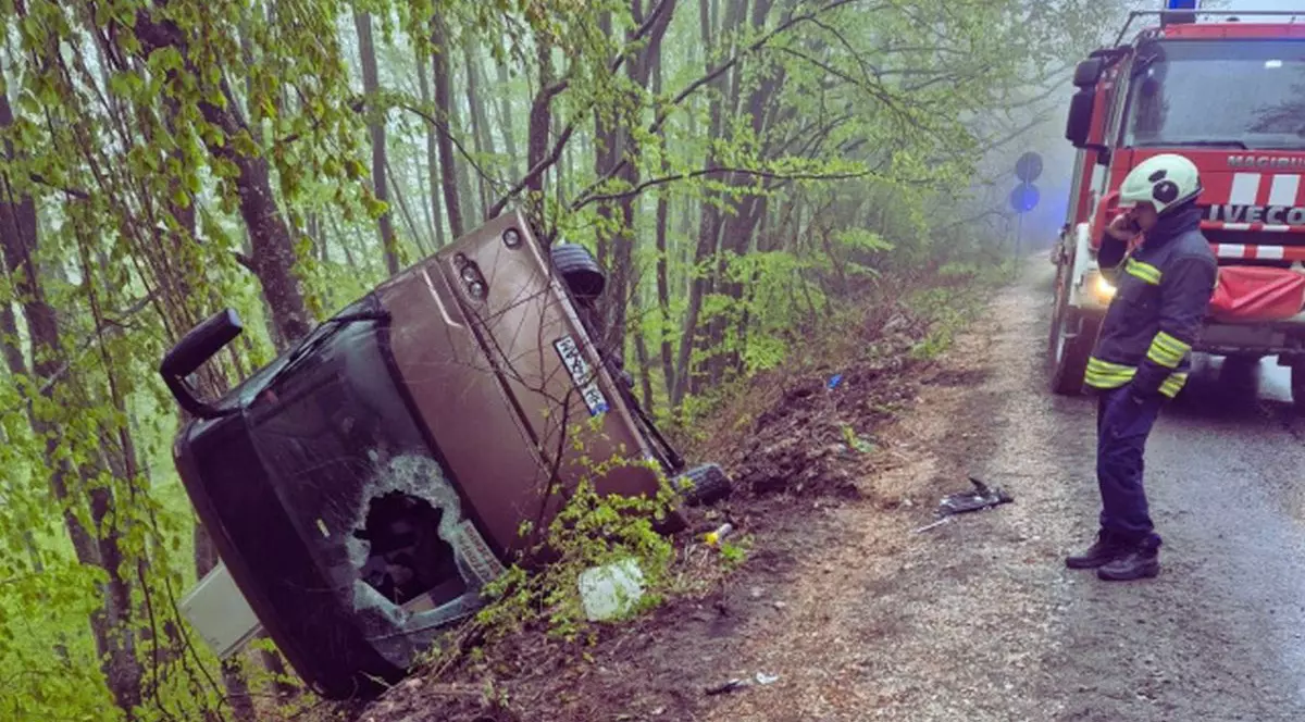 Un autobuz este răsturnat într-un șanț de pe marginea șoselei, în timp ce pompierii intervin la locul incidentului, Bulgaria, 22 aprilie 2026