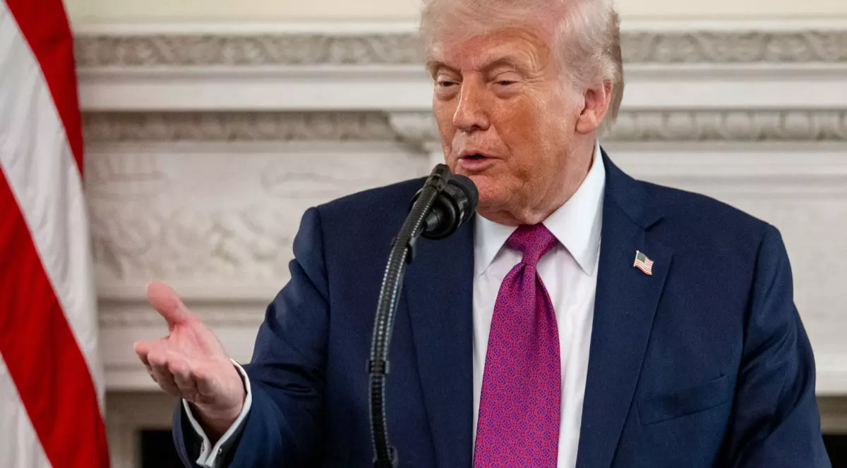 Președintele american Donald Trump, în timpul unei conferințe de presă la Casa Albă, poartă un costum albastru și o cravată mov și gesticulează