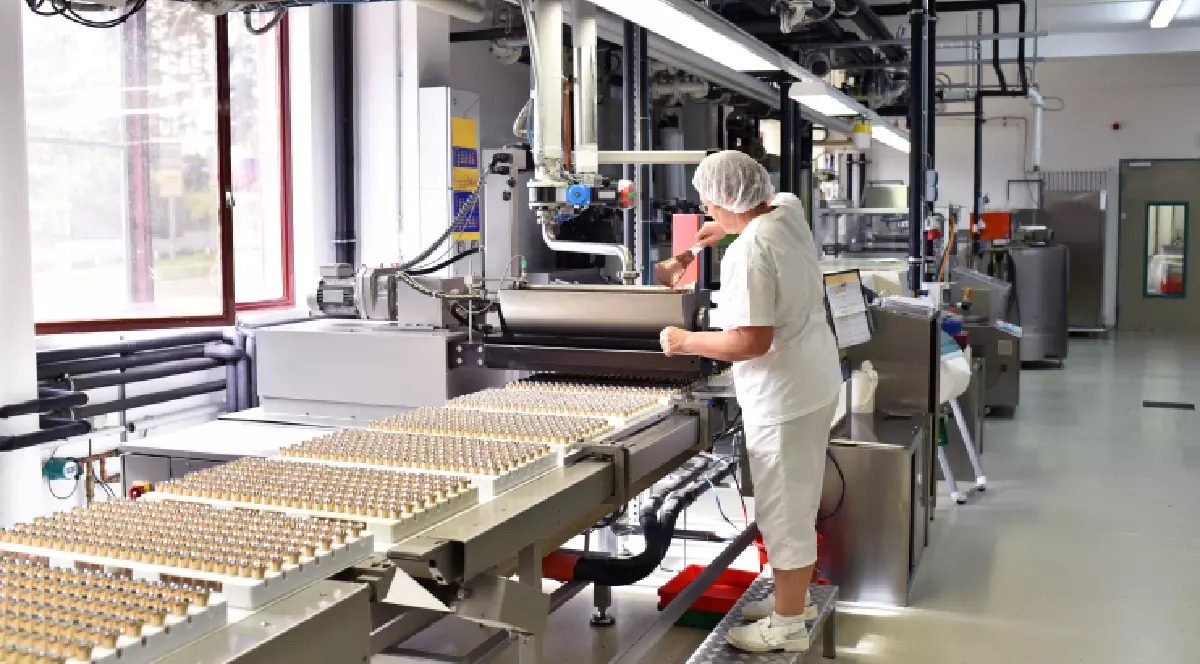 Producția de praline într-o fabrică pentru industria alimentară: o femeie verifică ciocolata