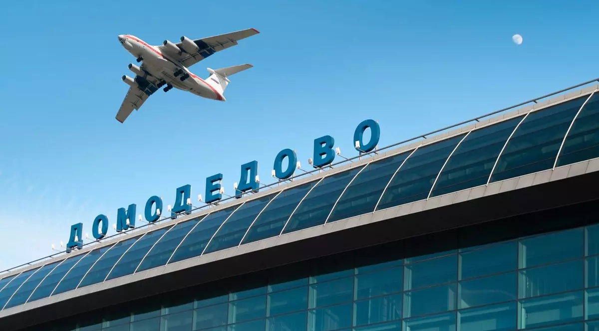 Exteriorul clădirii aeroportului internațional din Moscova și un avion zburând pe cerul albastru. Domodedovo. Rusia
