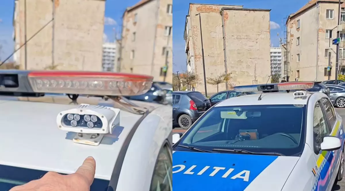O mână arată un dispozitiv LPR care este pus pe o mașină de poliție. În spate se mai vede o mașină de poliție.