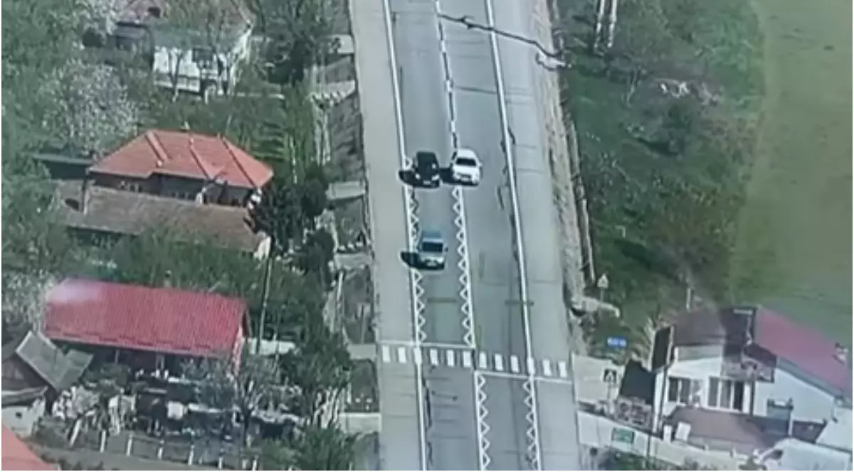 O mașină albă văzută din elicopter, care depășește pe linia continuă