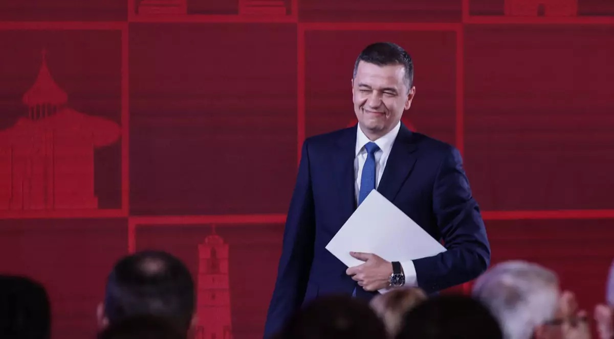 Sorin Grindeanu în costum negru, cămașă albă, în timp ce zâmbește