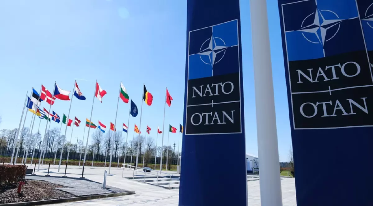 Alfabetul fonetic NATO - Imagine având în prim-plan steaguri ale organizaţiei NATO şi în plan secundar steagurile ţărilor membre