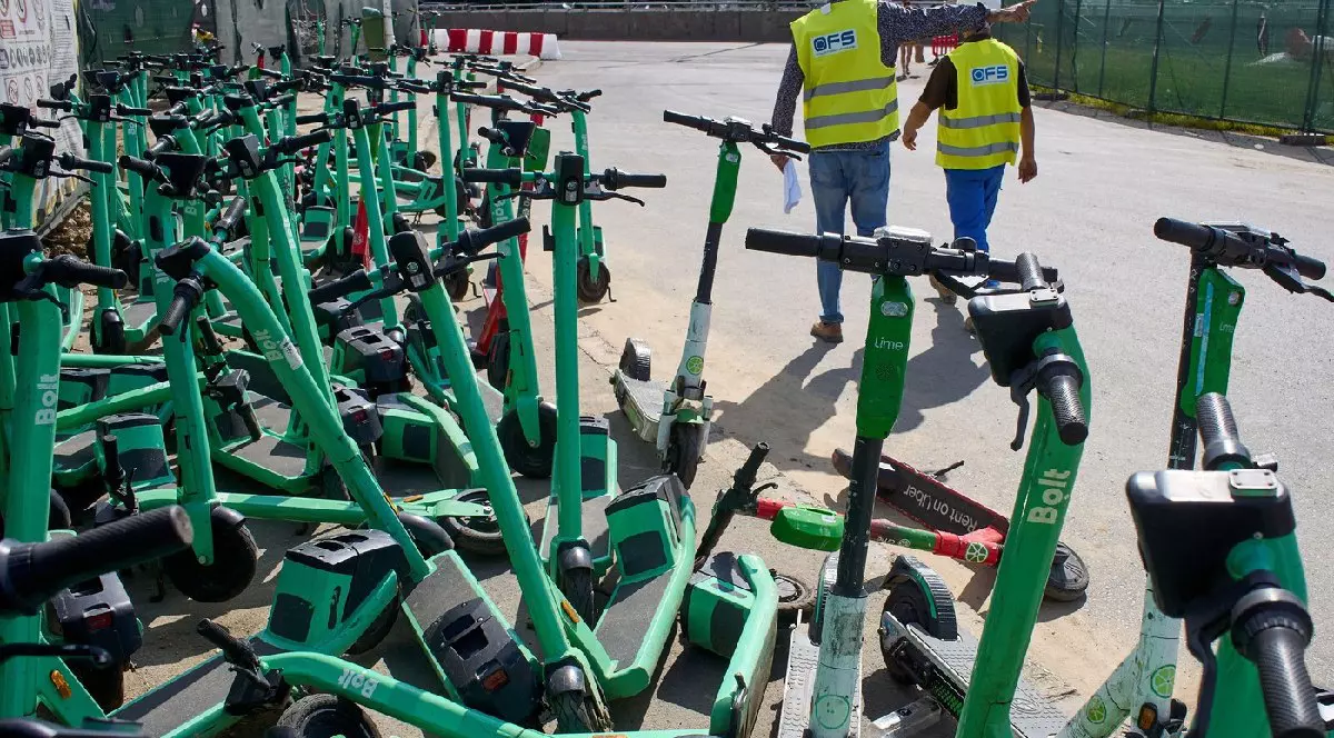 Trotinete electrice verzi, de închiriat, îngrămădite pe un trotuar