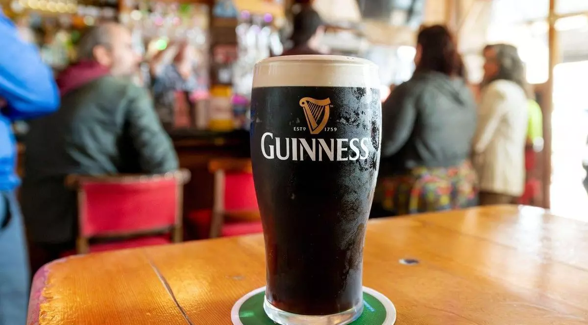 Vedere generală a unei halbe pline de bere Guinness irlandeză dry stout într-un pub colorat și aglomerat din orașul Cobh, Irlanda. Foto: Profimedia.