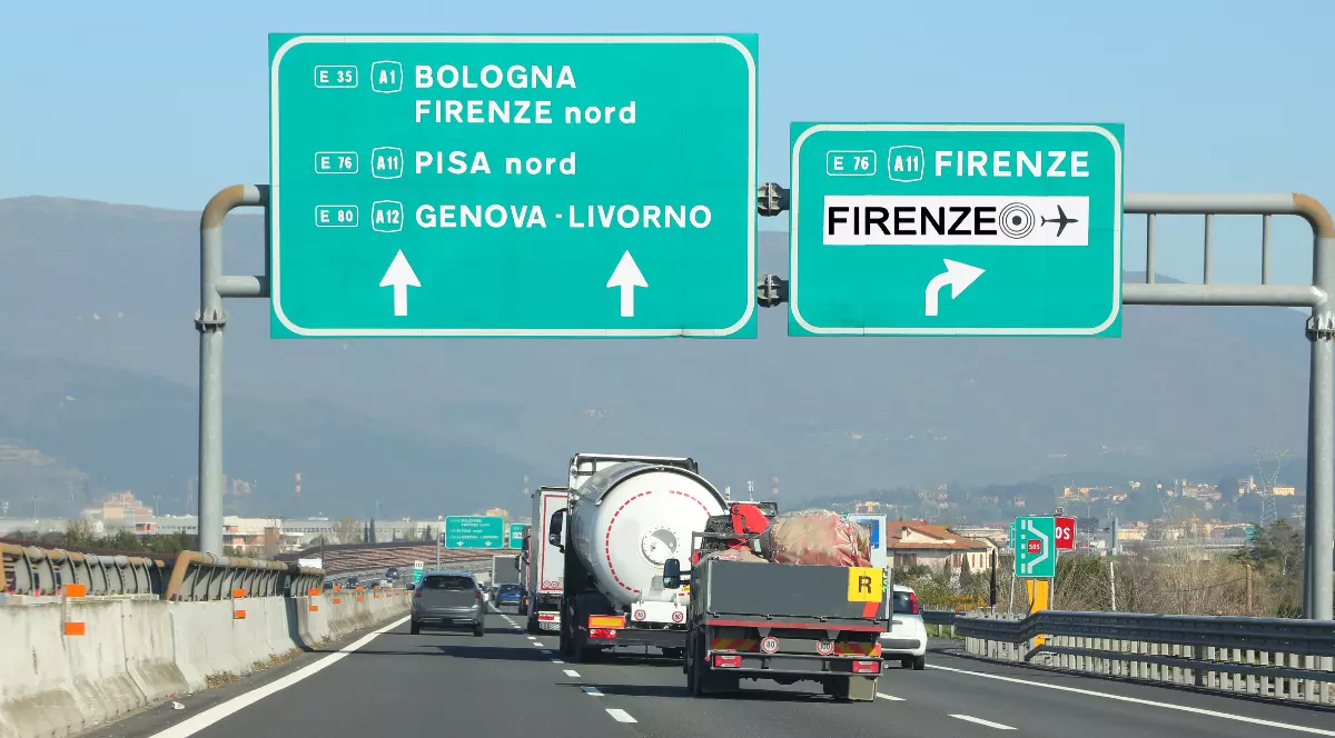 Imaginea prezintă trafic aglomerat pe o autostradă dn Italia, cu mai multe vehicule care circulă pe mai multe benzi