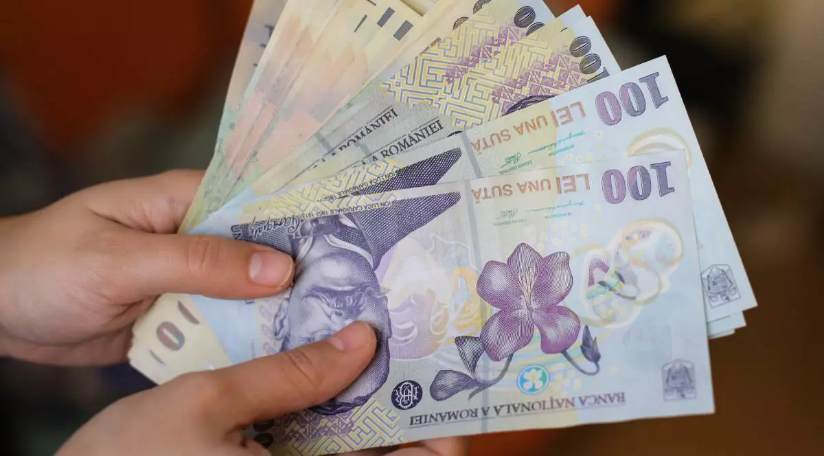 Mâinile unei femei care tin mai multi bani, lei