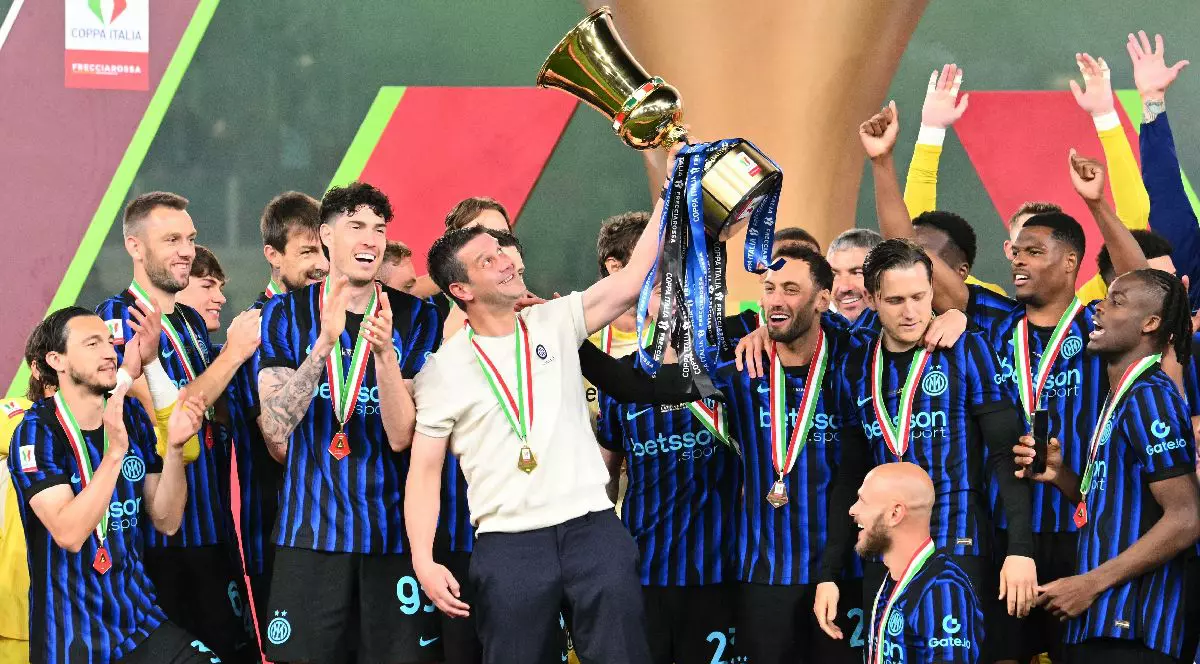 Mai mulți fotbaliști ai lui Inter, în tricouri albastru negru și în fața loc Cristi Chivu, în tricou alb, cu Cupa Italiei într-o mână