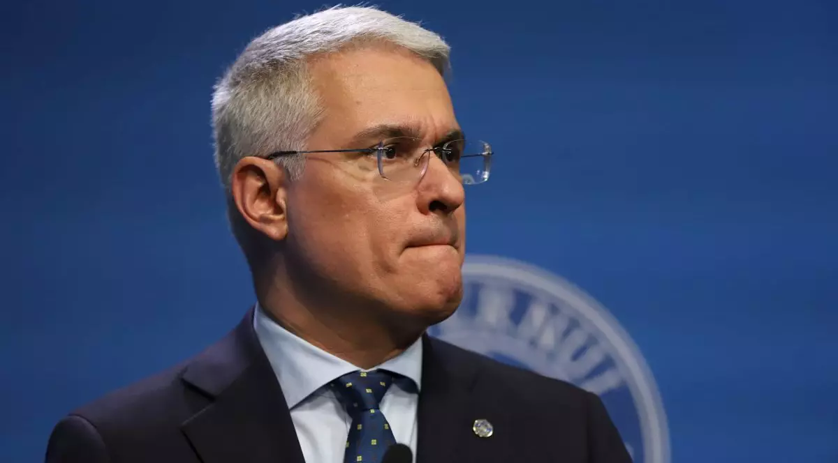 Ministrul interimar la Muncii, Dragoș Pîslaru, îmbrăcat la costum și cu ochelari, vorbește la o conferință de presă, iar în spate are un fundal albastru, București, martie 2026