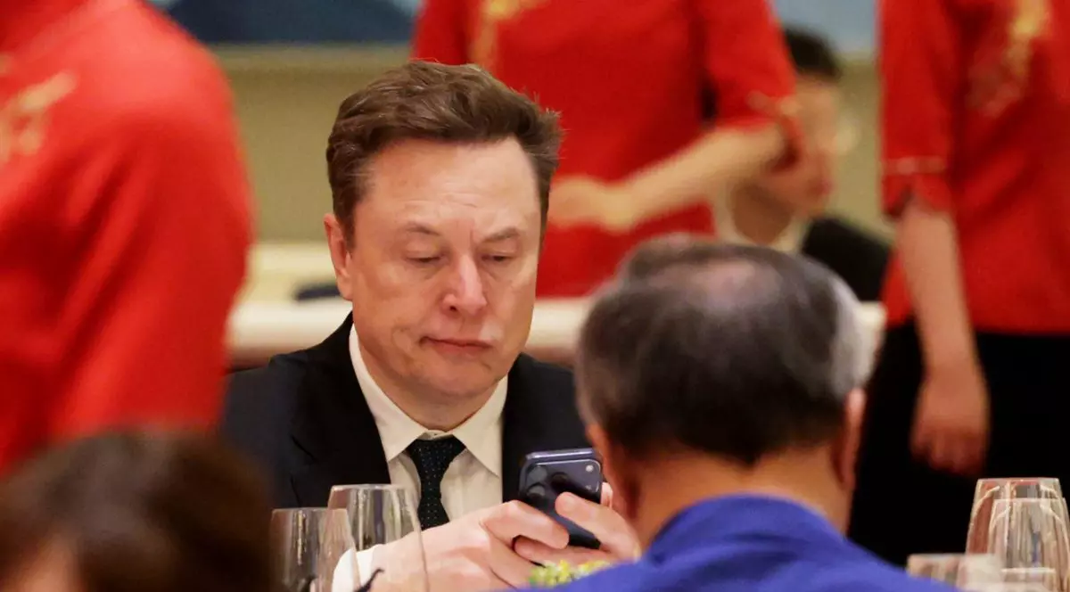 Elon Musk se uită încruntat la telefonul său în timpul bufetului dat de Xi Jinping în China.
