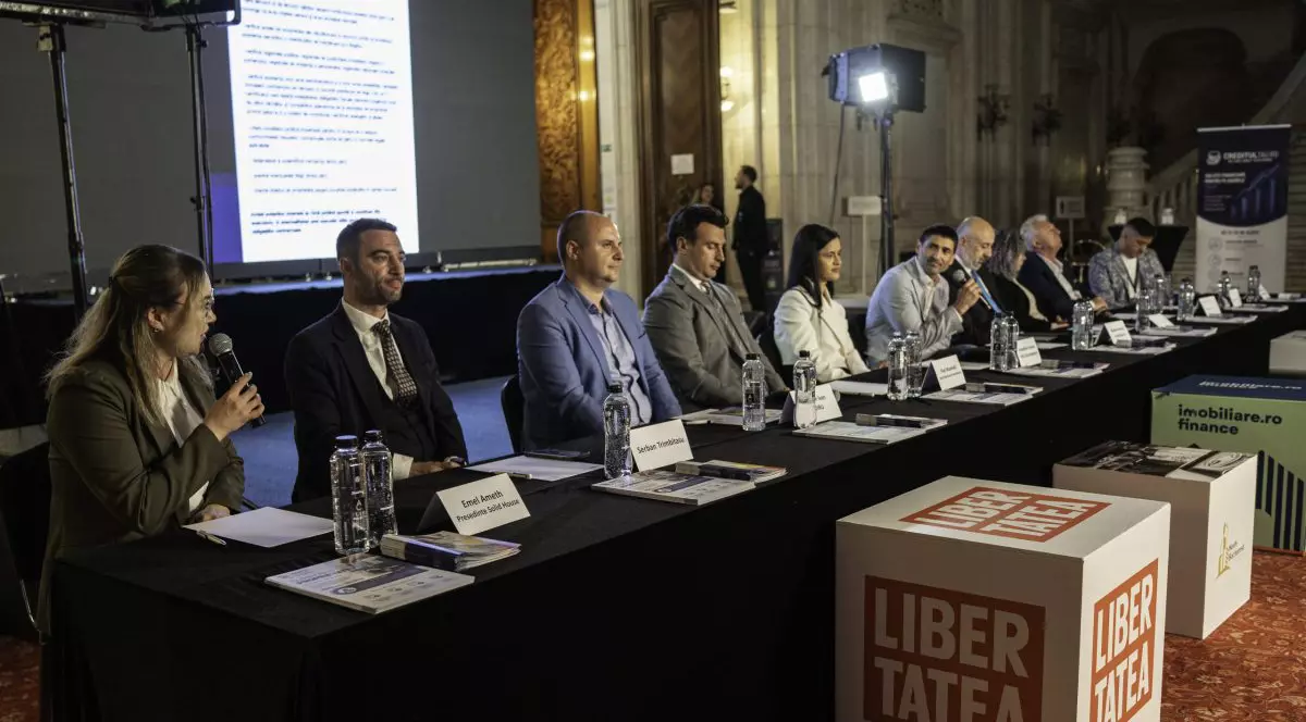 Emel Amet vorbește la microfon la Salonul Imobiliar București, alături de alți experți din industrie.