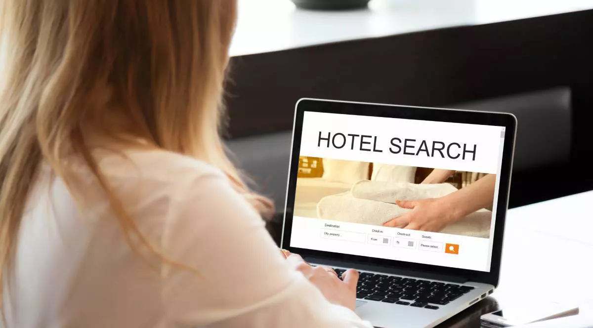 Tânără femeie care lucrează la laptop, în căutarea de cazare folosind serviciul web online