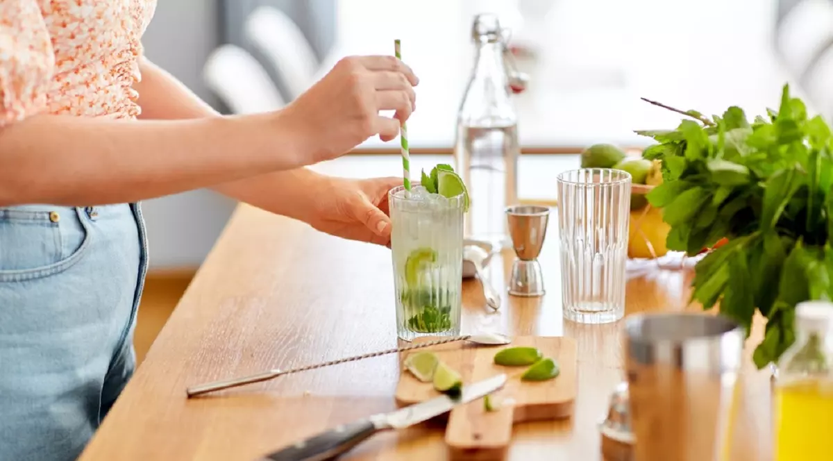 Arta mixologiei acasă: 3 cocktailuri celebre pe care le poți face singur - Imagine care pregăteşte un mojito in bucătăria proprie
