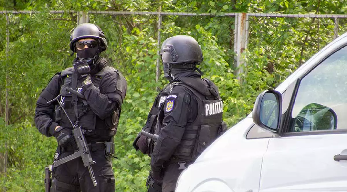Doi polițiști din Forțele Speciale ale Poliției Române, în fața unei dube albe