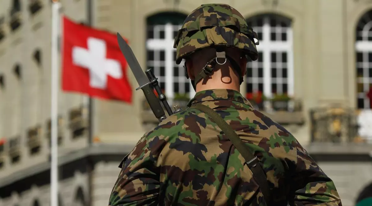Un soldat elvețian stă în poziție de drepți în fața unui steag elvețian înainte de sosirea președintelui german Christian Wulff, pe 8 septembrie 2010, la Berna, Elveția.
