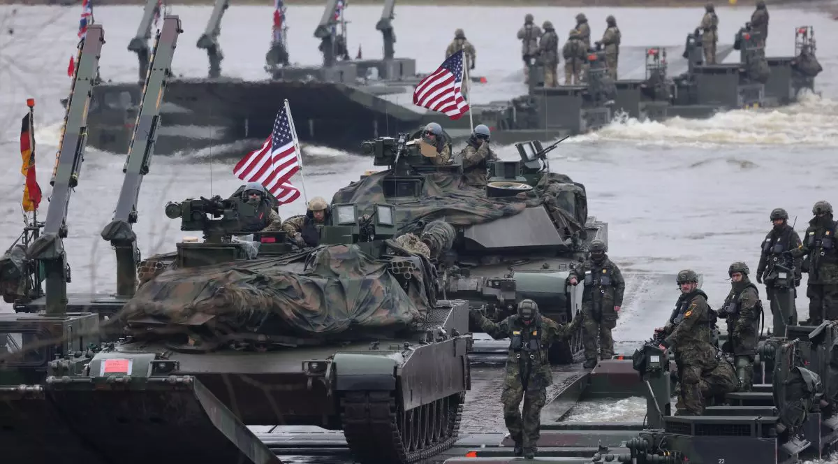 Tancuri de luptă M1A2 Abrams ale Armatei SUA, echipate cu platforme amfibii M3 ale Batalionului 130 de Geniu Amfibiu Germano-Britanic, traversează râul Vistula în timpul exercițiului militar NATO Dragon 24, desfășurat pe 5 martie 2024 lângă Gniew, Polonia