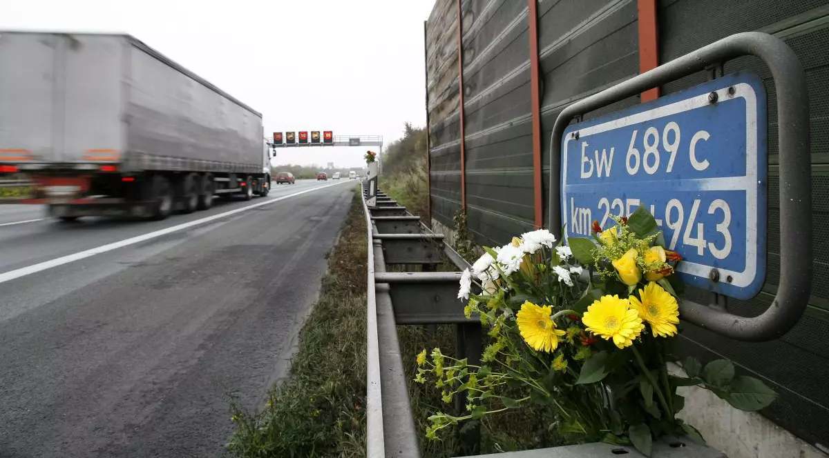 Un TIR trece prin locul în care au fost puse flori după un accinet mortal, pe o autostradă din Germania, 4 noiembrie 2008