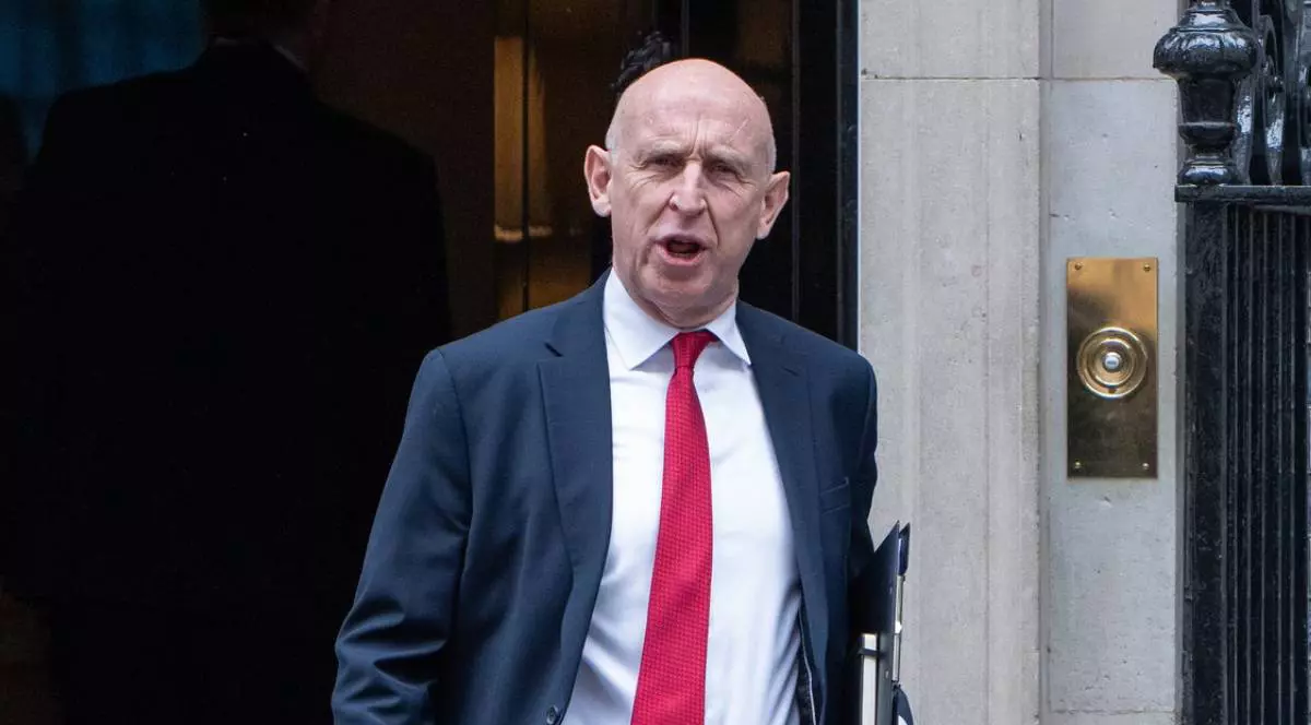 JOHN HEALEY, ministrul Apărării, in sacou gri inchis, camasa alba, cravata roșie si cu o mapă la subraț, părăsește Downing Street nr. 10 după o ședință săptămânală de cabinet.