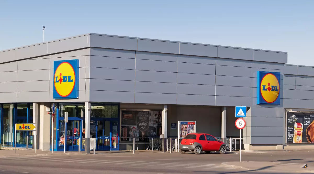 Un supermarket Lidl din România, o mașina roșie este parcată la intrare